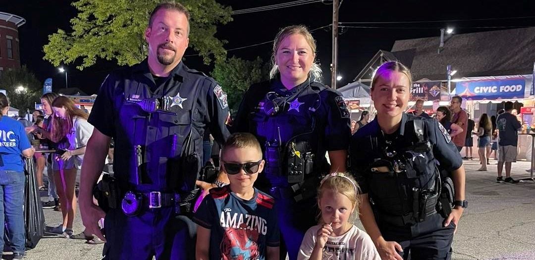 Officers standing with kids at a National Night Out Event